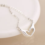 Silver plated heart hands necklace