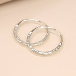 Sterling silver flat hammered hoop earrings