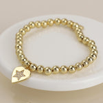Golden beaded heart charm bracelet with pave crystal star