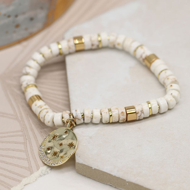 White bead bracelet with golden star disc charm