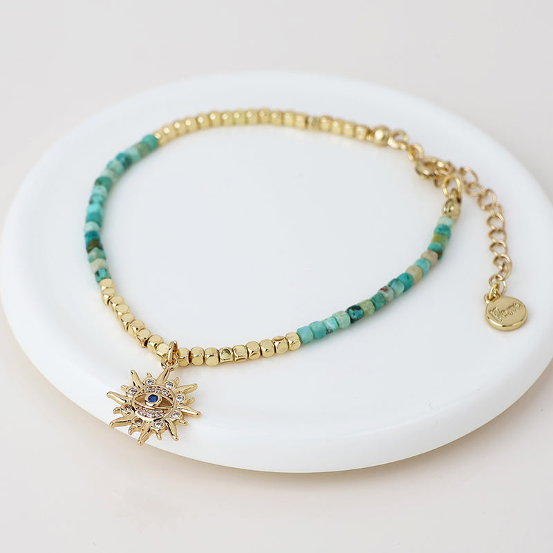 Golden and turquoise bracelet with crystal sun charm